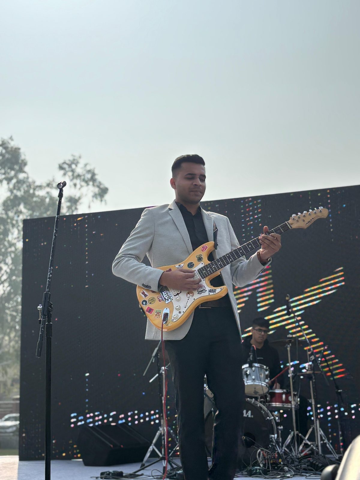 Abhishek performing on stage with an electric guitar