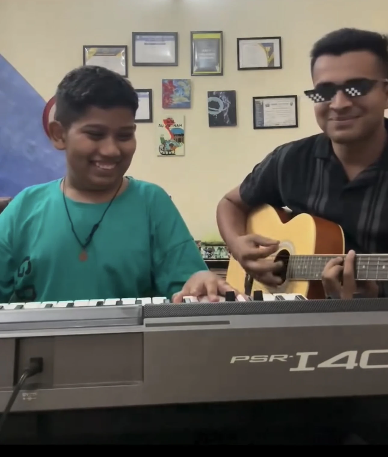 A student and teacher jamming on keyboard and guitar